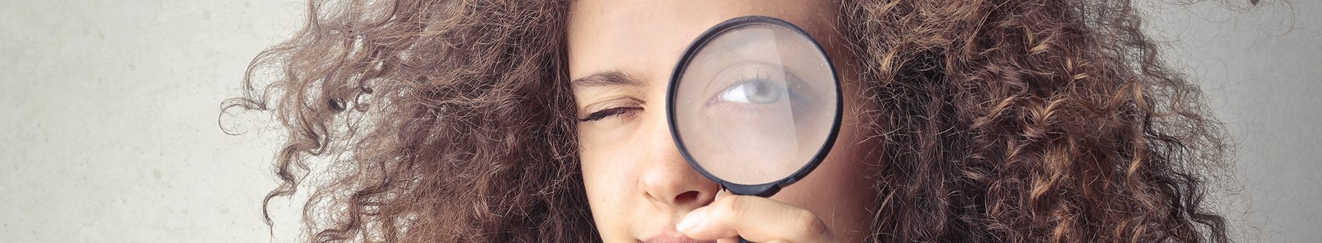 portrait-photo-of-woman-holding-up-a-magnifying-glass-over-3771107